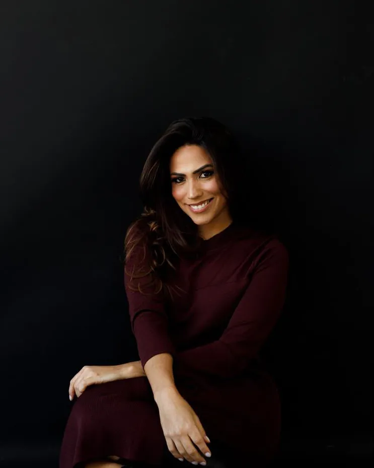 Dra. Dieme Schettert sentada, sorrindo, em fundo preto